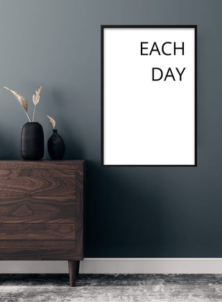 Minimalist "Each Day" poster on a dark wall above a wooden dresser with decorative vases.
