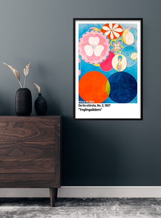 Framed "De ti största nr. 2" poster by Hilma af Klint hanging on a wall above a wooden dresser.