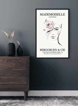 Framed Mademoiselle exhibition #3 poster featuring an abstract female face with a pink rose, displayed above a dresser.