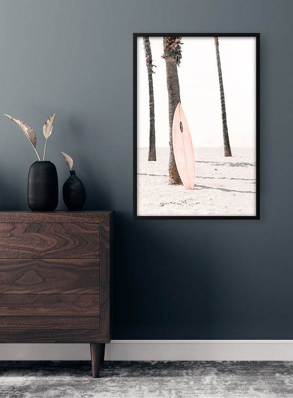Plakat med lyserødt surfbræt på stranden