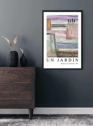 Framed "Un Jardin" poster inspired by Paul Klee, displayed on a dark wall above a wooden dresser.