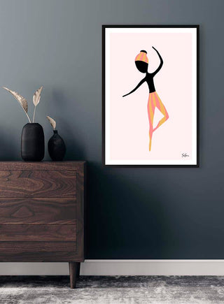 Framed abstract art print of a dancing figure, "Dance More" by Sara Sonne, displayed on a dark wall above a dresser.
