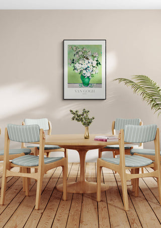 Framed Van Gogh Roses print displayed above a modern dining table with four chairs and a small vase of flowers.