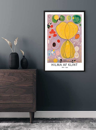 Framed Hilma af Klint "The Ten Largest, Adulthood, No. 7" poster hanging on a grey wall above a wooden dresser.
