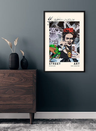 Framed Street Artsy Unique no. 2 poster with a colorful street art portrait, displayed above a dark wood dresser.