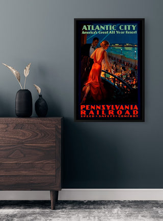 Framed Atlantic City vintage poster featuring a woman overlooking a lively boardwalk, displayed above a dresser.