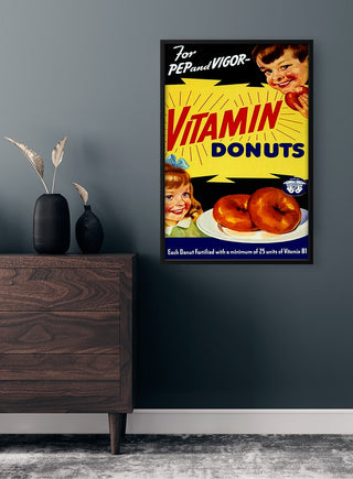 Vintage "Vitamin Donuts" poster on a modern wall, featuring cheerful children and donuts with bold retro text.