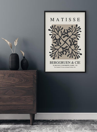 Papier Decoupe Coral Flower Plakat framed on a dark wall above a modern wooden dresser with decorative vases.