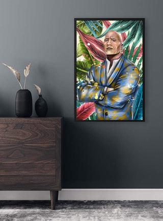 Colorful portrait of The Rock in a suit, arms crossed, with a vibrant leafy background, hanging on a dark wall.