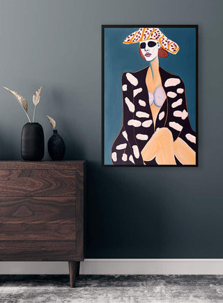 Framed “I Got A Feeling” by Tara Green on a dark wall above a wooden dresser with minimalist decor.