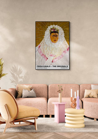 Poster of Frida Kahlo as Tehuana displayed on a beige wall above a modern pink and beige living room sofa.