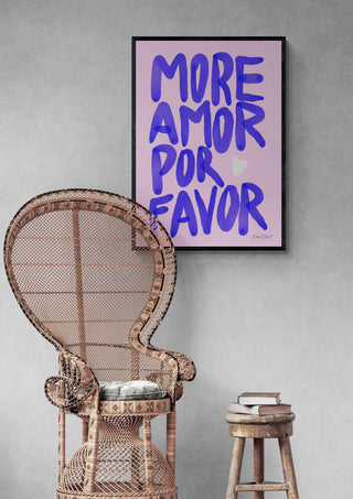 Baroo Bloom "More Amor Por Favor" art print on wall above wicker chair and stool with books.