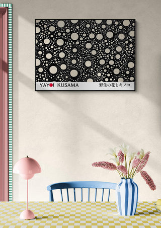 Yayoi Kusama - Black Dots Plakat on a wall above a pastel table, chair, and pink lamp in a modern room.