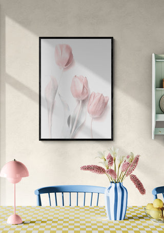 Framed Sweet Pink floral art print above a dining table with a blue chair and pink-themed decor.