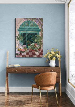 Framed French Flowershop - Goed Blauw art print above a wooden desk with vase of yellow flowers in a cozy room.