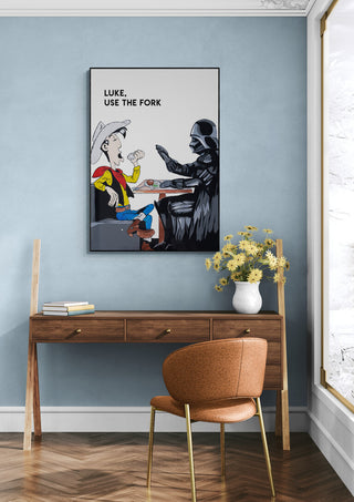 Framed "Luke, Use the Fork" artwork by Daniel Leo displayed above a wooden desk in a modern room.