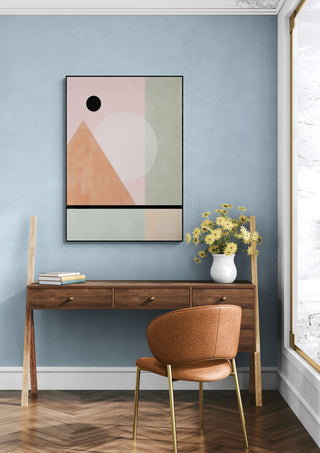 Abstract wall art with geometric shapes in pastel tones, displayed above a wooden desk in a modern room.