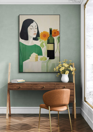 The Winer by David Wolf artwork above a wooden desk with chair, vase of yellow flowers, and pastel green wall.