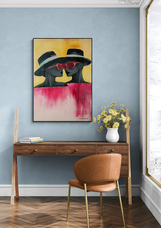 Two - David Wolf artwork on wall above wooden desk with chair and vase of flowers in stylish room setting.