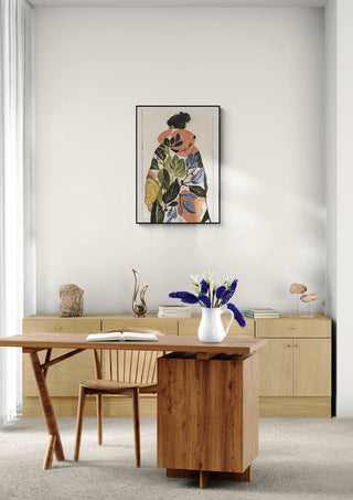 Elara Monet "Botanical Harmony" artwork framed above a minimalist wood desk and chair in a modern room.