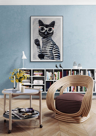 Framed "Im Kitty - Martin Zen" cat art hanging above a modern chair in a stylish, cozy reading nook.