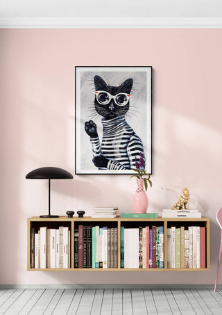 Framed "Im Kitty - Martin Zen" cat artwork hanging above a modern bookshelf against a pink wall.