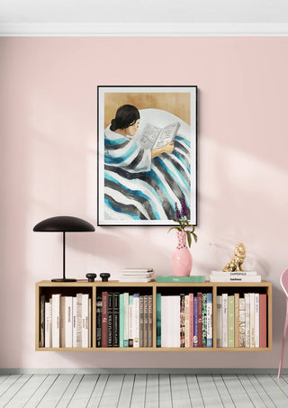 Framed "Moment of Peace" by Martin Zen above a modern bookshelf with decor on a pink wall.