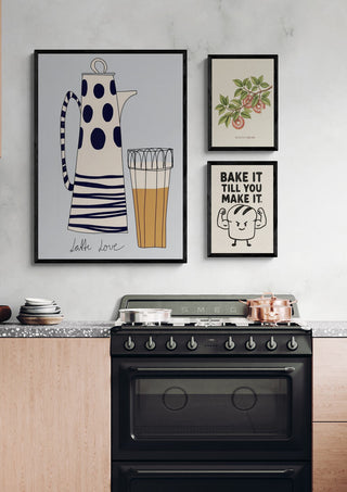 Framed "Bake it till you make it" print from Donut Worry on a kitchen wall above a stove.