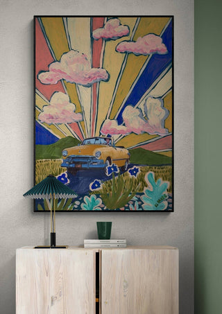 Colorful painting of a yellow car under radiant skies with pink clouds, displayed above a modern cabinet.