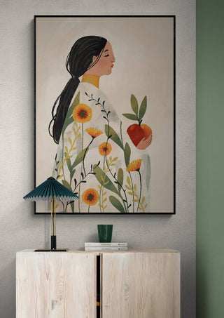 Framed artwork of a woman holding an apple, with floral patterns on her dress, by Elara Monet.