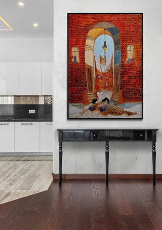 Framed painting of two cats in a brick alleyway displayed above a black console table in a modern room.